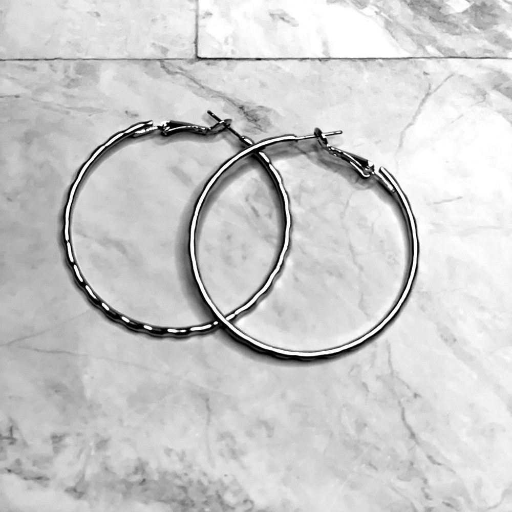Silver tone hoop earring with easy closure.